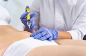 Cropped photo of a female patient in lingerie getting a fat-dissolving injection into the abdomen